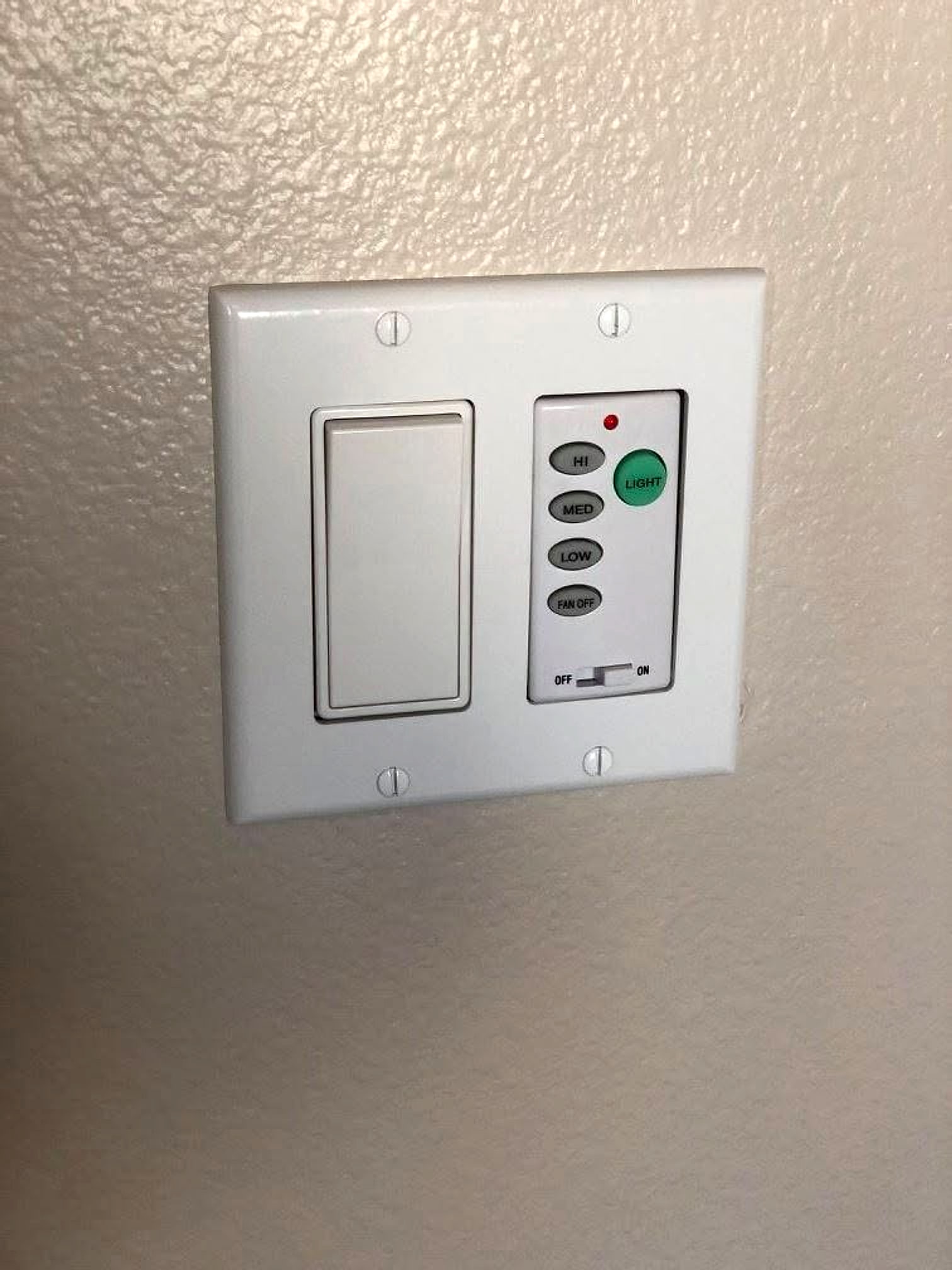 Rocker switch next to a fan and light control