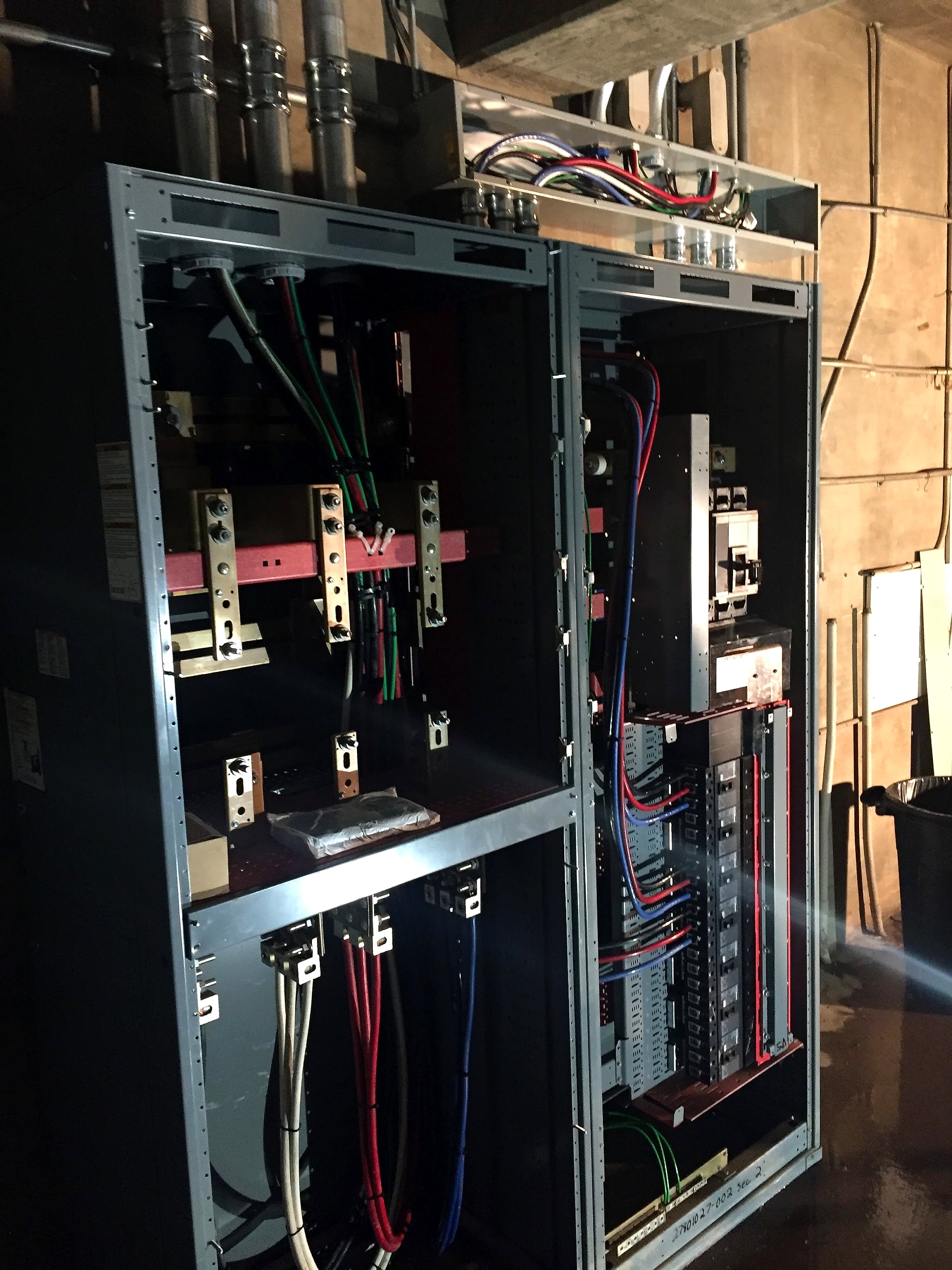 Open distribution panels with fresh wiring on an Amped Electric job